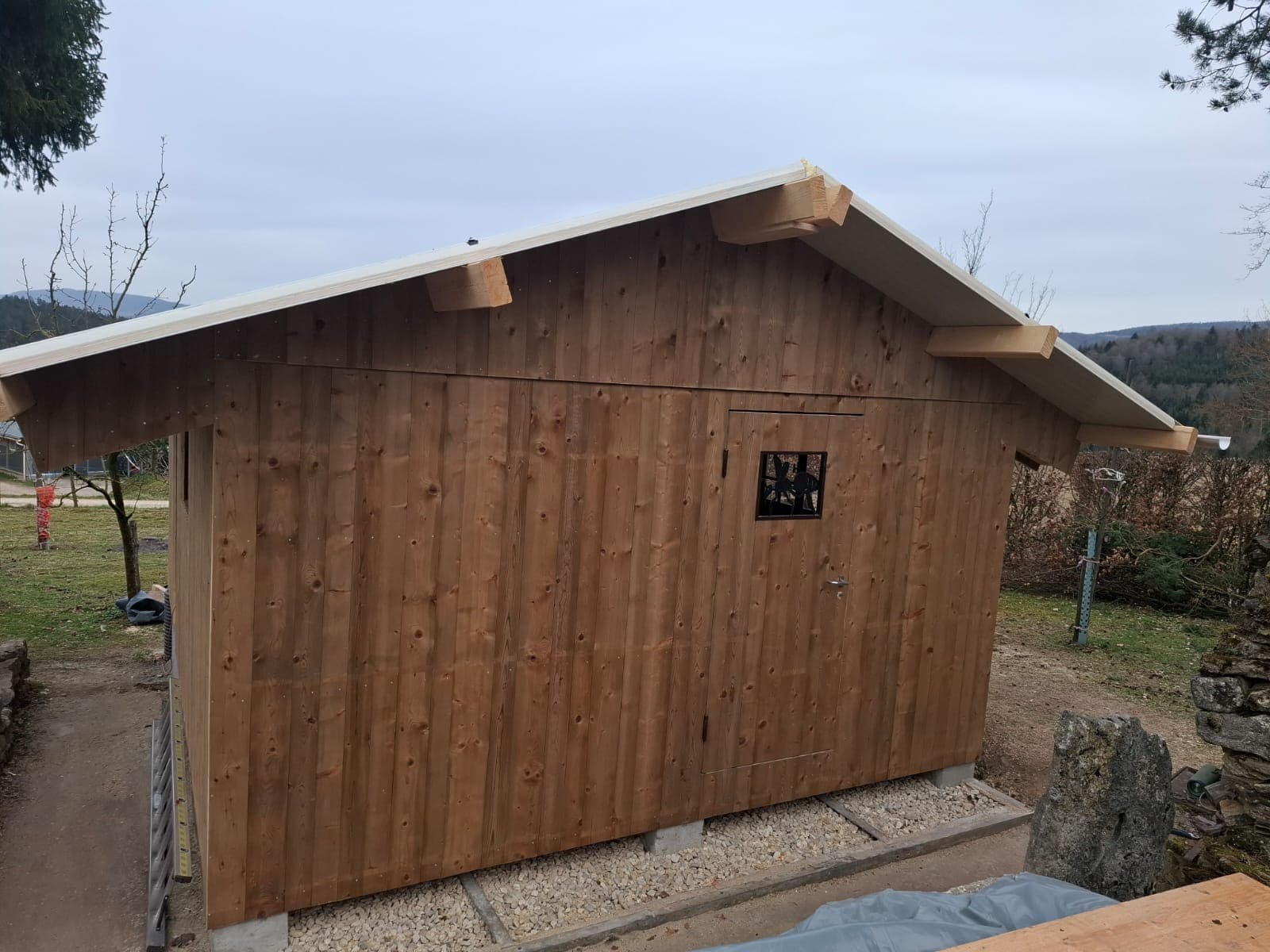 Timber outbuilding with natural vertical cladding in winter landscape