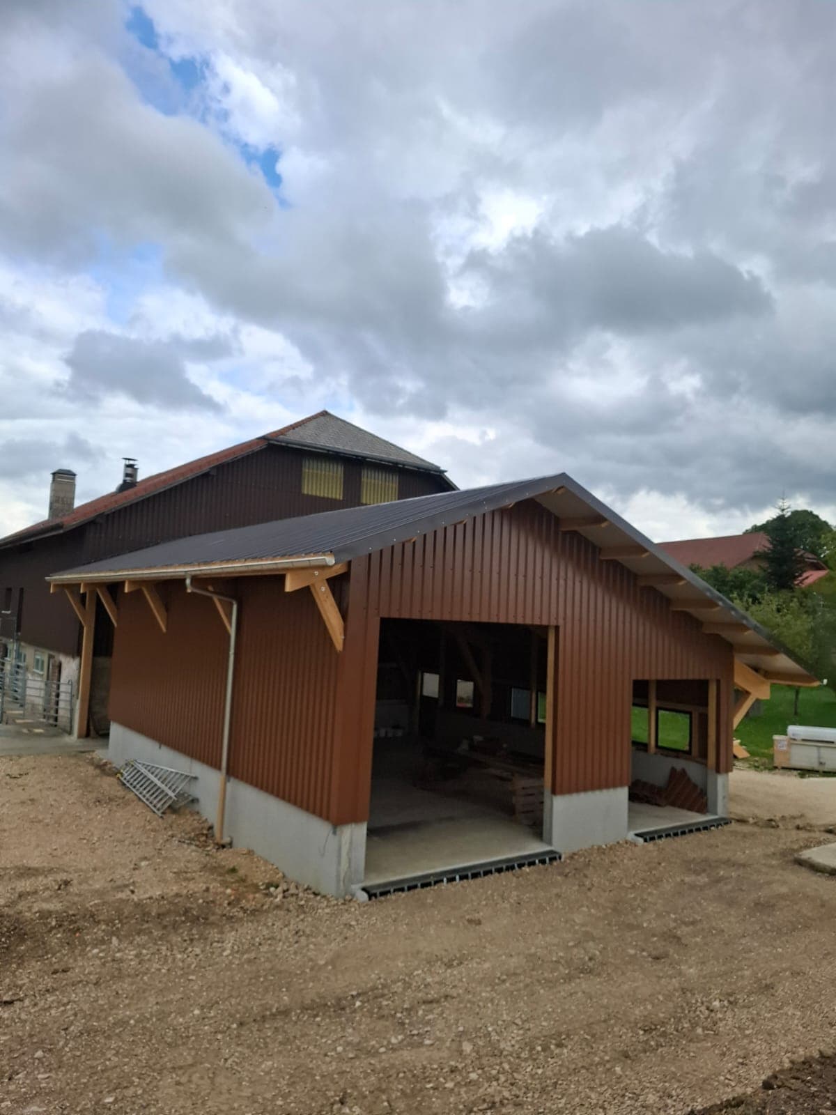 Agricultural hall under construction in a Swiss farm setting