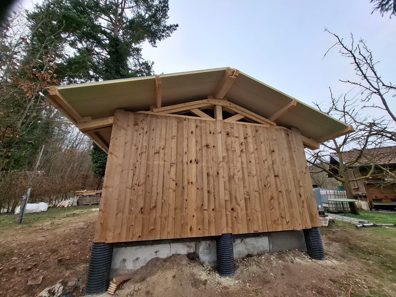 Timber construction with distinctive overhanging roof structure on concrete piers