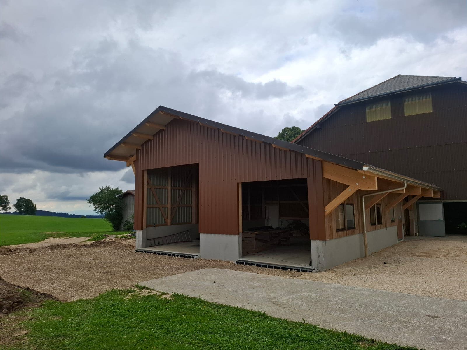 Completed agricultural hall with open bay and green field