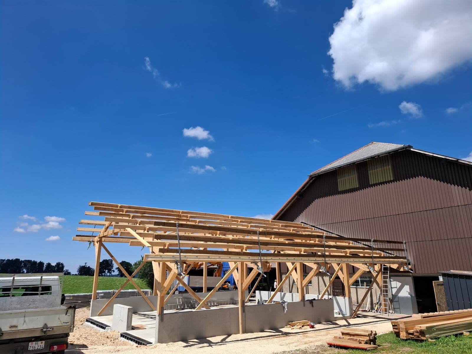 Timber frame structure under construction on a clear blue-sky day