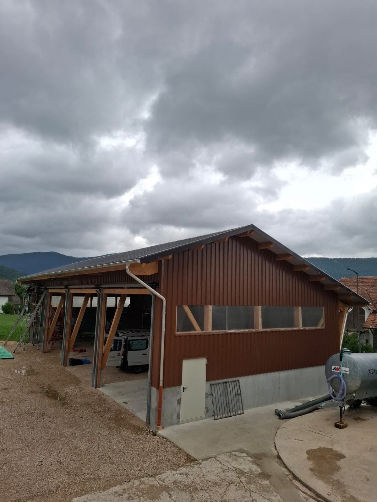 Agricultural hall exterior against a dramatic overcast Swiss sky