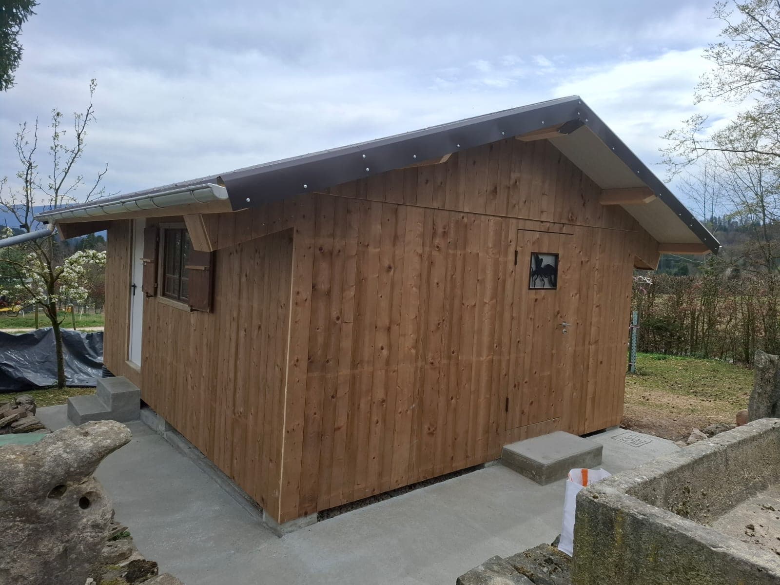 Completed timber outbuilding with natural cladding and metal roof